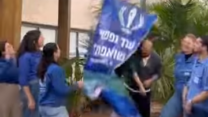 איתן הורן מוריד שלט שקרא לשחרורו, לצד מדריכים ורכזים שעבדו איתו בתנועת המחנות העולים (צילום: המחנות העולים)
