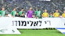 שחקני הקבוצות והילדים מחזיקים שלט נגד אלימות לפני שריקת הפתיחה בסמי עופר (צילום: באדיבות מכבי חיפה)