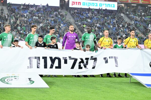 שחקני הקבוצות והילדים מחזיקים שלט נגד אלימות לפני שריקת הפתיחה בסמי עופר (צילום: באדיבות מכבי חיפה)