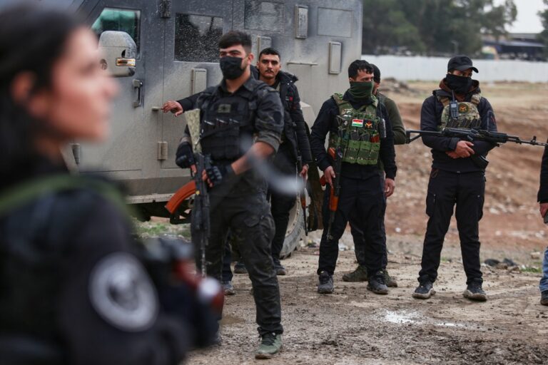 חיילת כורדית בכוחות ה-SDF מסתכלת על כוחות ביטחון המשטר הסורי שנכנסו לרוג'בה (צילום: AP Photo/Baderkhan Ahmad)