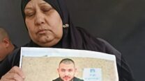 בושרא עמאש עם תמונת בנה עימאד (צילום: יניב שרון)