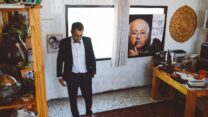 מיראס נאטור ביום חתונתו, לצד תמונת אביו הסופר סלמאן נאטור (צילום: אלבום פרטי)