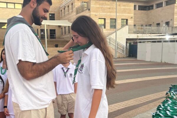 אורן מקבלת מבנימיני את העניבה, שמסמלת שנבחרה להדריך בקורס הכנה להדרכה (צילום: אלבום פרטי)