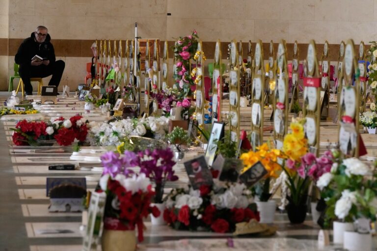 גבר מתפלל לצד קברים של חמושי חיזבאללה סעיד אל-פיטר, ברובע הדאחיה בביירות (צילום: AP)