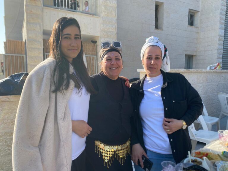 סימה עובדיה (במרכז) וחברותיה סמוך לזירת הפגיעה הישירה בבית שמש. "עד אתמול בכיתי, עד אתמול לא חשבתי שנחגוג" (צילום: יהל פרג')