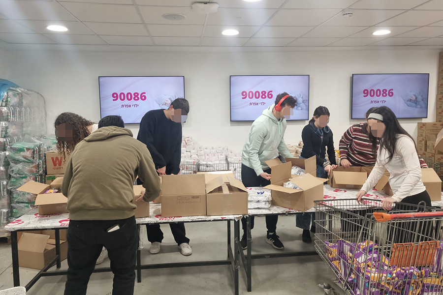 מתנדבי מסע אורזים מזון כחלק מאגודת אפרת (צילום: אלבום פרטי)