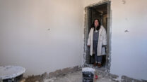 רינת כרמל בפתח הממ"ד הבנוי למחצה בבית אביה במושב זרעית. "לא מבינה איך אנחנו שוב במלחמה, ושוב אין מיגון" (צילום: דוד טברסקי)