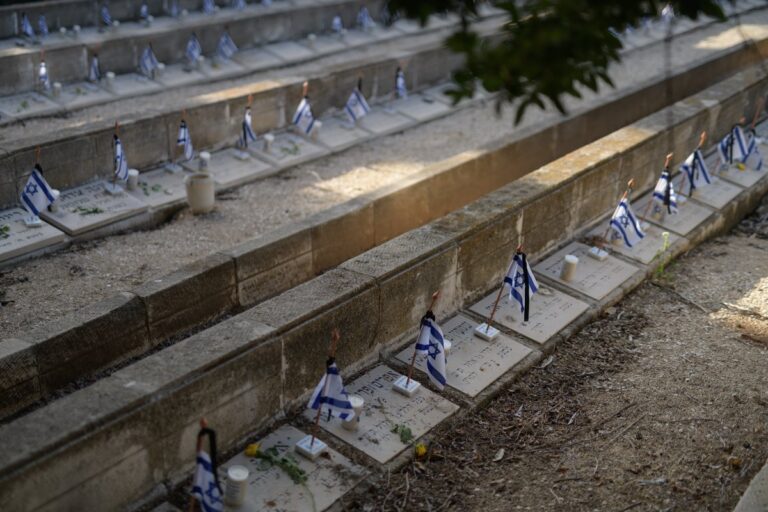 דגלונים, פרחים ונרות זיכרון על הקברים בחלקה שבה קבורים הרוגי ההפגזות של צבא איטליה על תל אביב במלחמת העולם השנייה (1940). בהפגזות על העיר נהרגו 137 בני אדם (צילום: יונתן בלום)
