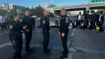 מפגינים חרדים חוסמים את כביש 4 ולצדם כוחות המשטרה (צילום: דוברות המשטרה)
