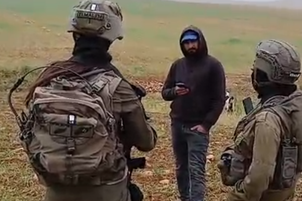 מתנחל לבוש קפוצ'ון משוחח עם שני חיילי צה"ל בשטח (צילום: פעילי בקעת הירדן)