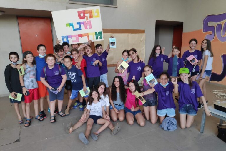 גיא לודר (למעלה, מחובק, מתחת לשלט) עם קבוצתו ביובלים (צילום: אלבום פרטי)