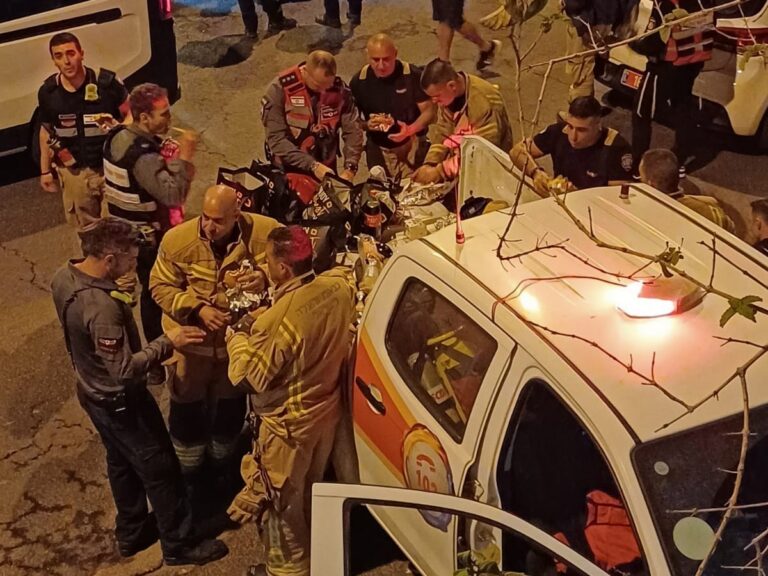 הכבאים אוכלים את משלוח ההמבורגרים שהגיע לזירה (צילום: אמיתי פרץ)