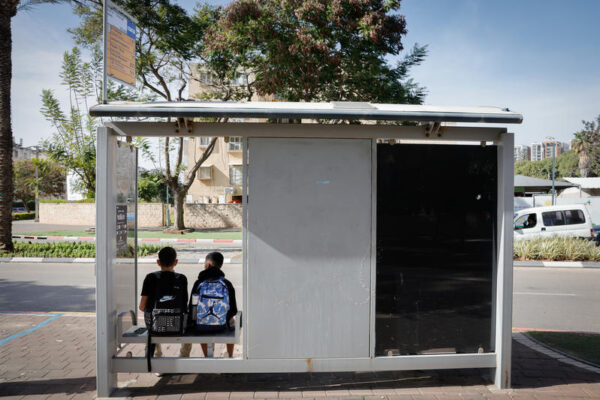 נערים ממתינים בתחנת אוטובוס באור יהודה, פברואר 2026 (צילום: נתי שוחט/פלאש90)