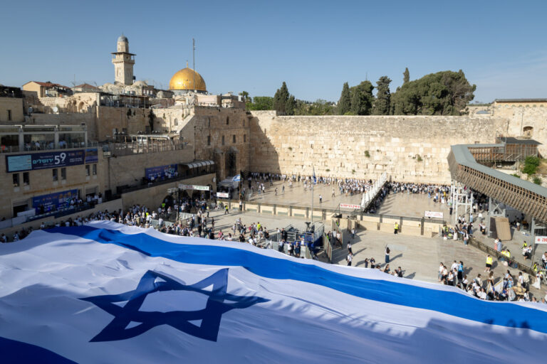 אנשים מחזיקים דגל ישראל ברחבת הכותל אחרי צעדת הדגלים בירושלים (צילום: פלאש 90)