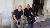 מחוץ ל"מספרה הכי טובה בעיר" בטייבה. התושבים סאלם נור וסעד אג'חייה אופטימיים לגבי הדור הבא: "יש אוטובוסים, אבל זה לא מספיק" (צילום: אמיתי פרץ)