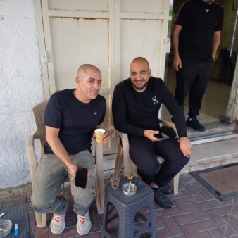 מחוץ ל"מספרה הכי טובה בעיר" בטייבה. התושבים סאלם נור וסעד אג'חייה אופטימיים לגבי הדור הבא: "יש אוטובוסים, אבל זה לא מספיק" (צילום: אמיתי פרץ)