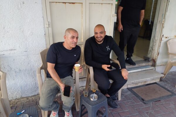 מחוץ ל"מספרה הכי טובה בעיר" בטייבה. התושבים סאלם נור וסעד אג'חייה אופטימיים לגבי הדור הבא: "יש אוטובוסים, אבל זה לא מספיק" (צילום: אמיתי פרץ)