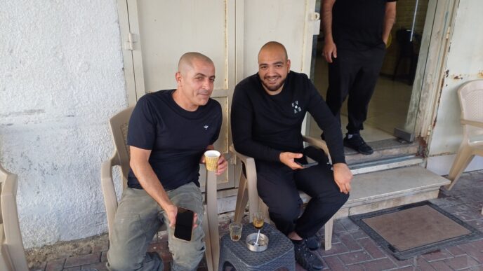 סאלם נור וסעד אג'חייה מחוץ ל"מספרה הכי טובה בעיר" בטייבה. "לנו זה פחות עוזר, אבל לצעירים זה יעשה הרבה טוב" (צילום: אמיתי פרץ)