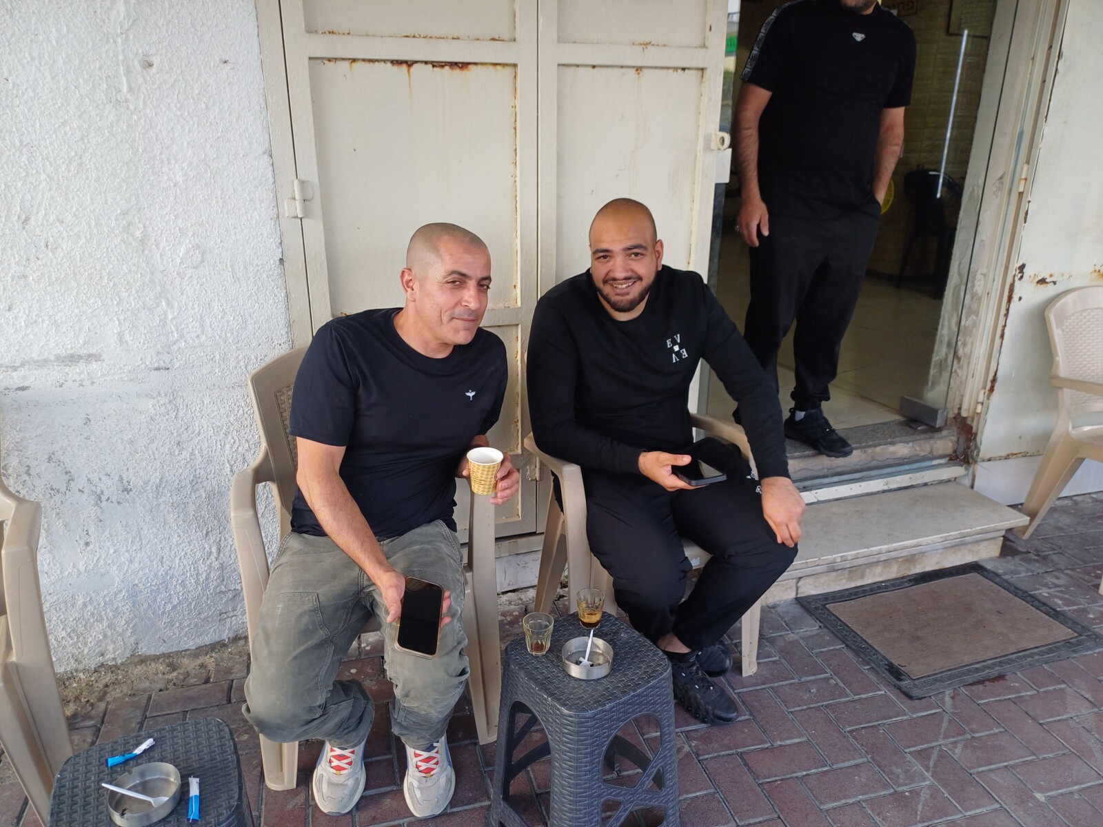 מחוץ ל"מספרה הכי טובה בעיר" בטייבה. התושבים סאלם נור וסעד אג'חייה אופטימיים לגבי הדור הבא: "יש אוטובוסים, אבל זה לא מספיק" (צילום: אמיתי פרץ)