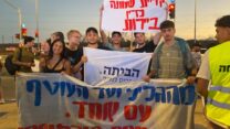 אוהד אברהמי (במרכז, אוחז בשלט 'הביתה') וחבריו בהפגנה בצומת הקשתות (צילום: יהל פרג')