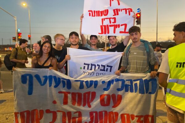 אוהד אברהמי (במרכז, אוחז בשלט 'הביתה') וחבריו בהפגנה בצומת הקשתות (צילום: יהל פרג')