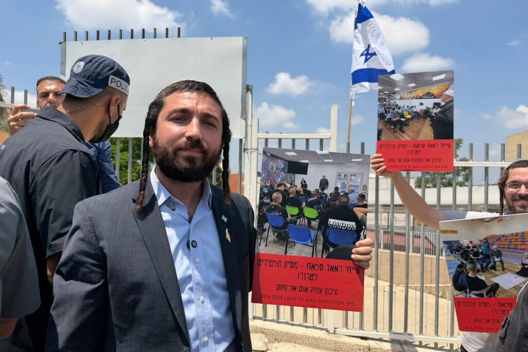 יו"ר ועדת החינוך, ח"כ צבי סוכות, מחוץ לשערי חטיבת הביניים הנעולה באום אל-פחם. ברקע: דגל ישראל שתקע בשער המוסד והשלטים שהובאו למקום (צילום: דוברות משרד החינוך)