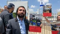 יו"ר ועדת החינוך, ח"כ צבי סוכות, מחוץ לשערי חטיבת הביניים הנעולה באום אל-פחם. ברקע: דגל ישראל שתקע בשער המוסד והשלטים שהובאו למקום (צילום: דוברות משרד החינוך)