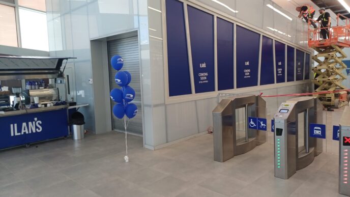 הבלונים כבר נתלו, אך עגלת הקפה של "אילנ'ס" נותרה יתומה ופועלים ממשיכים בעבודות הבנייה מעל שערי הכניסה ביום הפתיחה (צילום: אמיתי פרץ)