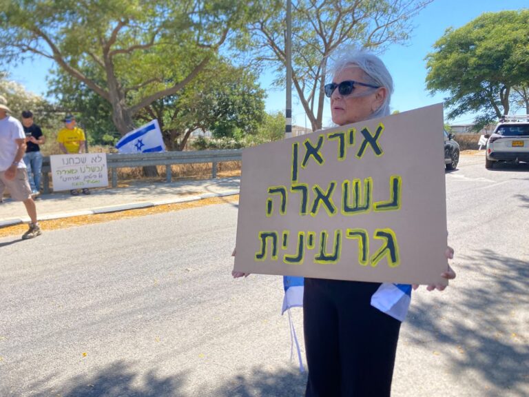 מפגינה בכניסה למושב עין השלושה (צילום: יהל פרג')