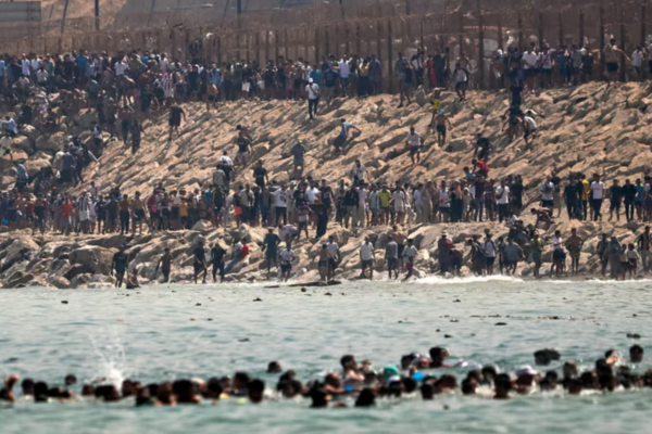 מאות מהגרים חוצים בשחייה את הגבול הימי ממרוקו למובלעת הספרדית סאוטה, אתמול. אלפים נוספים הגיעו לאזור הגדר ושובר הגלים בניסיון להיכנס לשטח ספרד (צילום: AP Photo/Antonio Sempere)