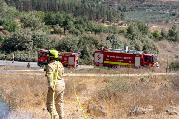 כוחות הכיבוי נערכים ופורסים קווי מים סמוך לכבאיות באזור שמשית, במטרה לבלום את התפשטות האש לעבר קו הבתים (צילום: טל סורסקי / כבאות והצלה לישראל)