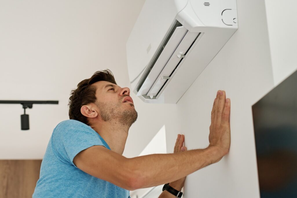 אדם עומד ליד המזגן ביום חם (אילוסטרציה: shutterstock)