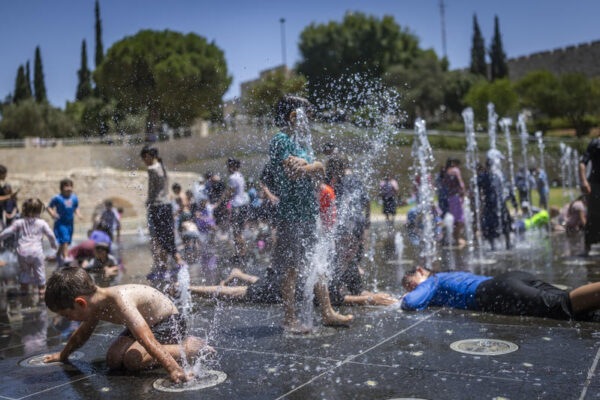 ילדים משחקים במזרקה בירושלים בשיאו של גל החום (צילום: יונתן זינדל/פלאש90)