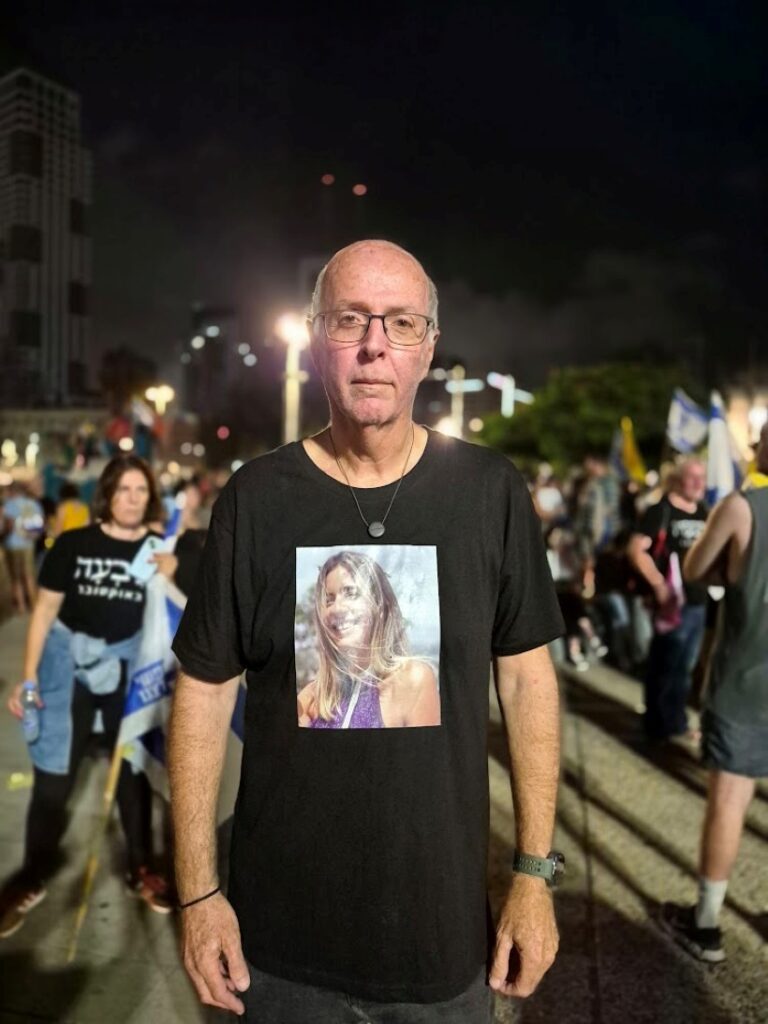 בני סולומון, אביה של הילי סולומון שנרצחה בנובה, עם תמונתה על חולצתו (צילום: יהל פרג')