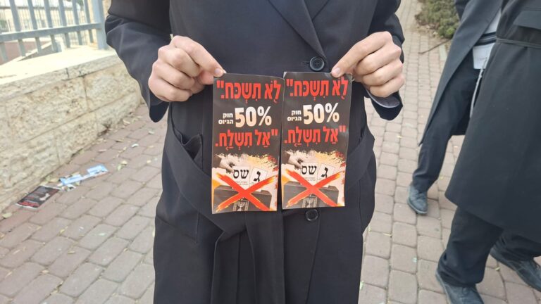 יהודה אוחז בכרוז הקורא לא להצביע בבחירות לכנסת (צילום: יובל לקח)